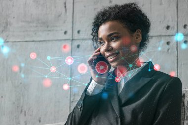 İş kadını telefonla ve soyut teknoloji hologramıyla konuşuyor. Çift pozlama.