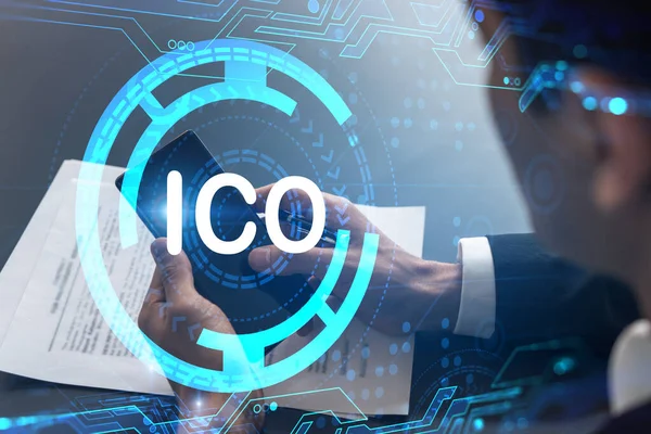 Smartphone, ICO hologramı ve daktilo ile çalışan bir analist. Çift pozlama.