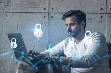 Ciddi bir Kafkasyalı programcı, verileri korumak için yeni bir güvenlik sistemi geliştirmek için dizüstü bilgisayar kullanıyor. Çifte maruziyet. IT hologram simgesini kilitle.