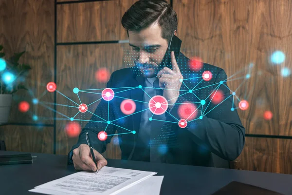 Un hombre en la oficina firmando papeles mientras habla holograma de tecnología móvil y abstracta. Doble exposición. Desgaste formal. — Foto de Stock