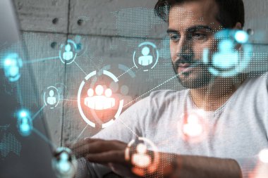 Yeni bir ağ geliştirmek için dizüstü bilgisayar kullanan ciddi bir Kafkasyalı yönetici. Çifte maruziyet. Sosyal medya hologramı.