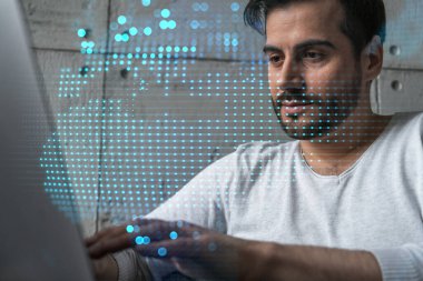 Dünya çapında yeni bir tedarik zinciri geliştirmek için dizüstü bilgisayar kullanan ciddi bir Kafkasyalı yönetici. Çifte maruziyet. dünya ve harita hologramı.