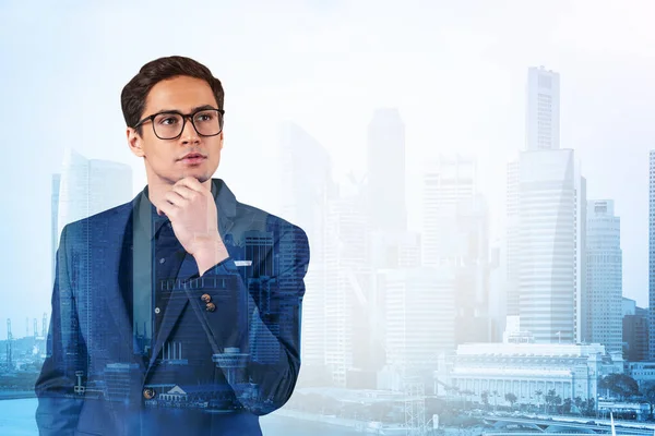 Joven hombre de negocios guapo en traje y gafas soñando con nuevas oportunidades de carrera después de la graduación del MBA. Singapur en segundo plano. Doble exposición. — Foto de Stock