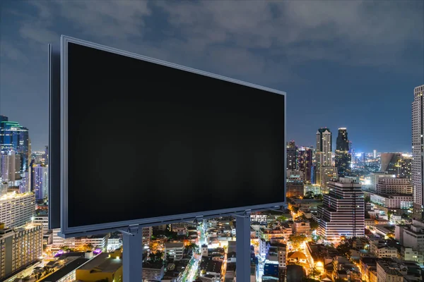 Blank black road billboard with Bangkok cityscape background at night time. Street advertising poster, mock up, 3D rendering. Side view. The concept of marketing communication to promote idea. — Stock Photo, Image