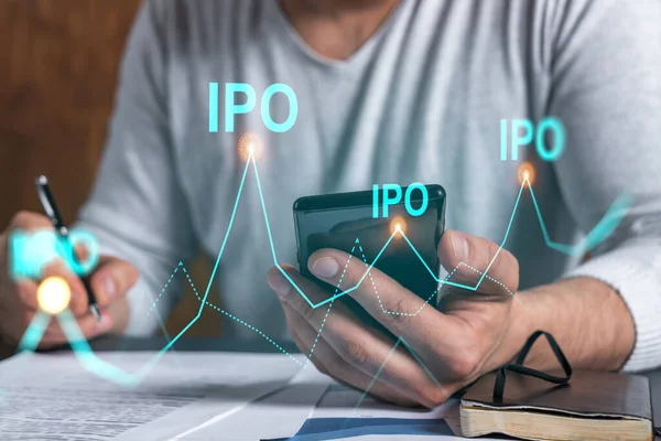 Двойное разоблачение человека, подписывающего контракт с телефоном и IPO-голограммой. Концепция первичного размещения, инвестиций. — стоковое фото