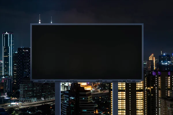 Blanco zwart wegreclamebord met Kuala Lumpur stadsgezicht achtergrond 's nachts. Reclameposter, model, 3D-weergave. Vooraanzicht. Begrip marketing om ideeën of producten te promoten of te verkopen. — Stockfoto