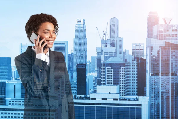 Успішно посміхаючись чорній афроамериканській бізнес-жінці в костюмі енергійної розмови по телефону, Сінгапурській цитаделі. Концепція консультантів як розв'язувачів проблем. Інвестиційний фонд. Подвійний вплив. — стокове фото