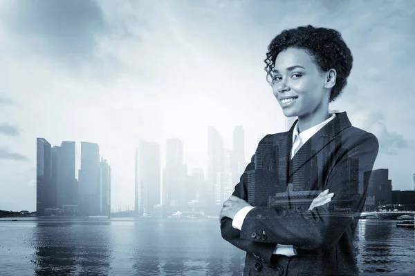 Smiling black African American business woman in suit in crossed arms pose. Singapore cityscape. The concept of woman in business. Investment fund. Double exposure.