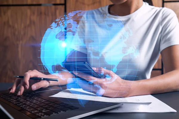 Zakenvrouw typt op laptop op kantoor. Planeet aarde wereldkaart hologram. Internationaal bedrijfsconcept. Dubbele blootstelling. — Stockfoto