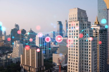 Soyut teknolojinin parlayan simgelerinin hologramı, günbatımında Bangkok 'un panoramik şehir manzarası, Asya. Dünyalar konsepti teknolojik değişiklikler. Çift pozlama.