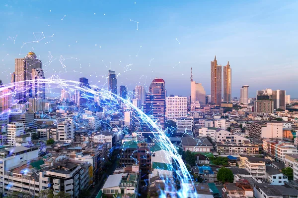 Soyut teknolojinin parlayan simgelerinin hologramı, günbatımında Bangkok 'un panoramik şehir manzarası, Asya. Dünyalar konsepti teknolojik değişiklikler. Çift pozlama.