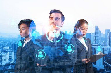 İş amaçlarına ulaşmak için sosyal medya pazarlama stratejisi üzerinde çalışan bir grup SMM uzmanı. Kuala Lumpur arkaplanı üzerinde hologram simgeleri.