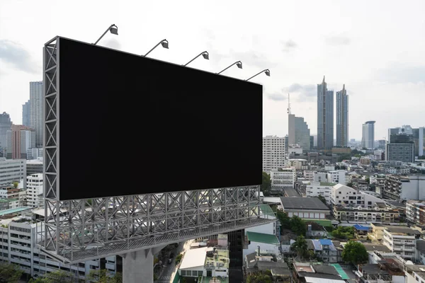 Blank black road billboard with Bangkok cityscape background at day time. Street advertising poster, mock up, 3D rendering. Side view. The concept of marketing communication to promote or sell idea.