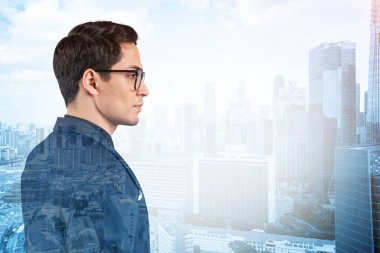 Takım elbiseli ve gözlüklü genç yakışıklı işadamı MBA mezuniyetinden sonra yeni kariyer fırsatları hayal ediyor. Singapur arka planda. Çift pozlama.