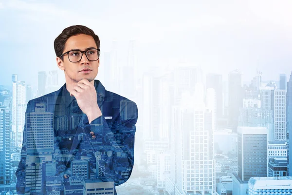 Joven hombre de negocios guapo en traje y gafas soñando con nuevas oportunidades de carrera después de la graduación del MBA. Kuala Lumpur en el fondo. Doble exposición. — Foto de Stock