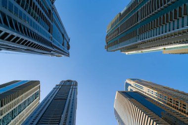 Güneşli bir günde Dubai, BAE 'nin finans merkezinin düşük açılı çelik ve cam gökdelenleri. Dubai Emirliği 'nin ofislerinin modern alçak açılı görüntüsü. Batı Asya 'nın iş merkezi..