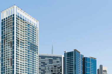 Güneşli bir günde Dubai, BAE 'nin finans merkezinin cam ve çelik gökdelenleri. Dubai Emirliği 'nin başkentinin dış binaları. Batı Asya 'nın uluslararası ticaret merkezi..