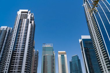 Güneşli bir günde Dubai, BAE 'nin finans merkezinin alçak açılı cam gökdelenleri. Dubai Emirliğinin başkentinin modern alçak açılı görüntüsü. Batı Asya 'nın uluslararası ticaret merkezi..