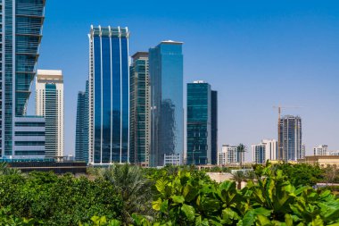 Güneşli bir günde Dubai şehir merkezinin ufuk çizgisine doğru çayırlara bakıyorum. Dubai, Birleşik Arap Emirlikleri 'nin en popüler şehri ve Batı Asya' nın iş merkezidir..