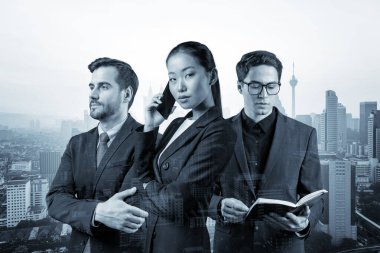 Takım elbiseli üç iş arkadaşından oluşan bir grup yeni kariyer fırsatları elde etmek için proje üzerinde birlikte çalışıyorlar. Çok uluslu şirket takımı kavramı. Kuala Lumpur. Çift pozlama.