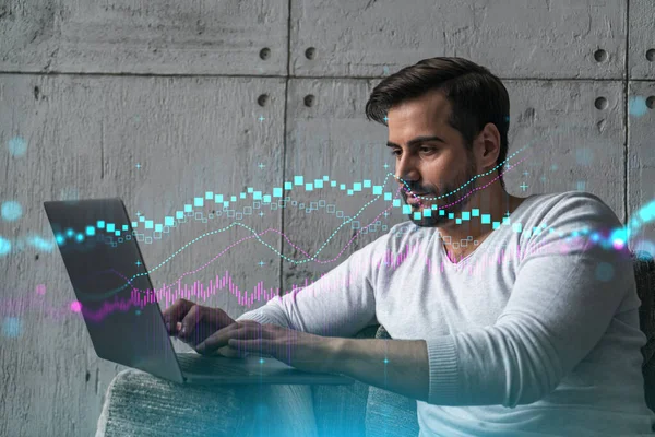 A serious caucasian analyst in casual wears, using laptop to proceed the forecast of stock market behavior. Double exposure. Forex Hologram. Concept of internet trading.