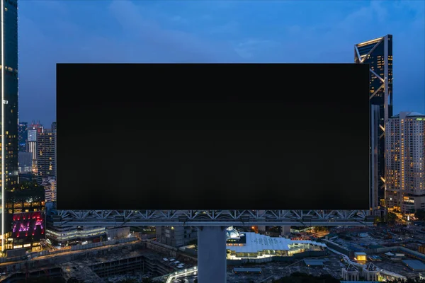 Blanco zwart wegreclamebord met Kuala Lumpur stadsgezicht achtergrond 's nachts. Reclameposter, model, 3D-weergave. Vooraanzicht. Begrip marketing om ideeën of producten te promoten of te verkopen. — Stockfoto