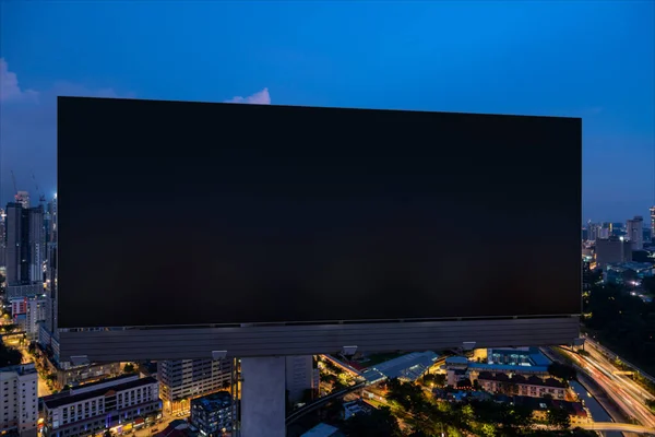 空旷的黑色路标与吉隆坡城市景观背景在夜间。街头广告海报，模拟，3D渲染。前面的景色促销或销售理念或产品的营销概念. — 图库照片