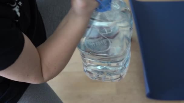 Дівчина Займається Підйомом Яти Літрів Пляшок Води Своїй Домашній Вітальні — стокове відео