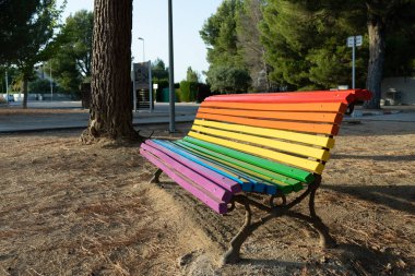 Gay bayrağının renklerine boyanmış bir sokak bankı