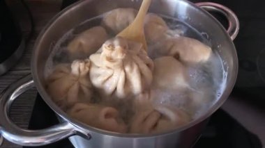 Khinkali kaynar suda mutfakta bir tavada pişirilir. Tahta bir kaşıkla karıştırılırlar ve biri alınır..