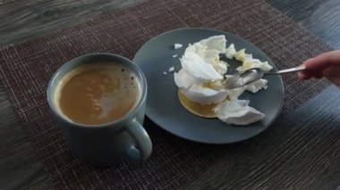 Kahve ve kremalı tatlı, parçalara ayrılmış, bir çay kaşığıyla hareket et.