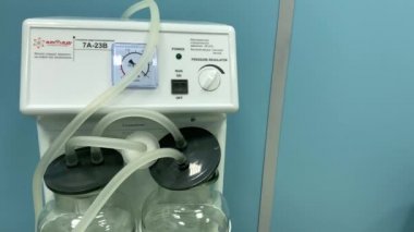İki büyük cam kap ve tüplü tıbbi cihaz. Cerrahi elektrik aspiratörü.