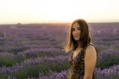 Brihuega, İspanya 'da yakalanan lavanta tarlasında yürüyen bir kadının yatay görüntüsü.