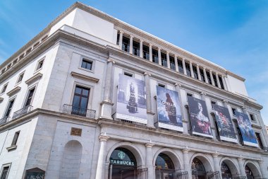 Madrid, İspanya. 19 Eylül 2025. Madrid Tiyatrosu 'nun arka cephesinde, güneşli bir günde, Plaza de Isabel II' de Kraliçe II. Isabel heykeliyle çekilmiş bir editör fotoğrafı..
