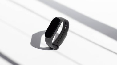 Beyaz arka planda akıllı aktivite fitness takip cihazı sabah güneşinin ışınları. Spor bileziği. Siyah fitness saati