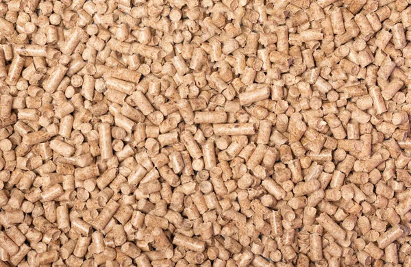 Texture of woody clumps, pellets of litter, for cat, rabbit, guinea pig, hamster, rodent, bird, turtle and other pets. Cat litter for a toilet close-up. Cat tray wooden.