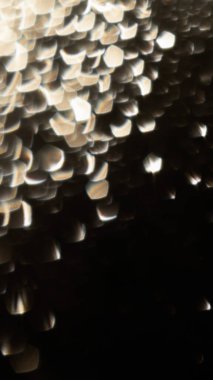 Siyah arka planda beyaz altın bokeh. Tatil, kutlama, yeni yıl ve Noel konsepti