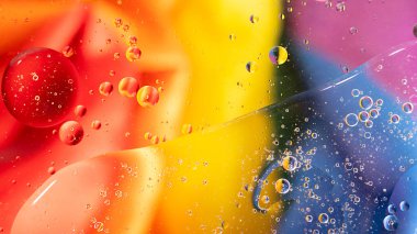 Renkli yağ kabarcıklarından oluşan fantastik bir yapı. Kaotik hareket. Soyut boya. Düz yatıyordu. Sıvının içinde kabarcıklar hareket ediyor. Su yüzeyi çok renkli arka plan. Makro Desen, tasarım. Gökkuşağı, LGBT.