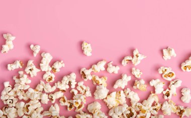 Pembe Arkaplan 'da patlamış mısır. Film izlerken atıştırmalık. Fotokopi alanı olan düz bir yer. Sinema ve eğlence anlayışı. Şablon.