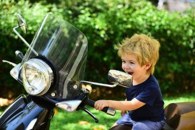 Mutlu çocuk taşıma, bir motosiklet üzerinde küçük sürücü joying. Yol ve seyahat. Bir motorcu ve mutlu yaz tatili. Bir motosiklet üzerinde güzel çekici çocuk. Motosiklet, hız, hareket