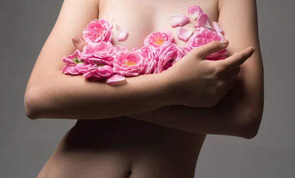 健康的女性乳房 乳腺癌 灰色背景的年轻美丽的女人 花花瓣在裸露的乳房 Intim 健康卫生 脱毛概念 美丽的女人身体与柔软的皮肤 — 图库照片