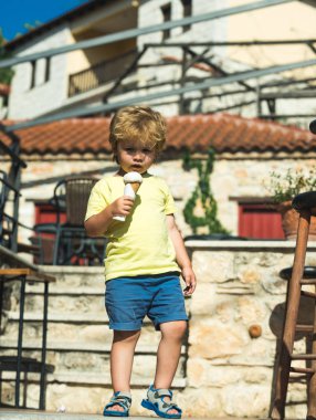 Komik çocuk dondurma ile şehir merkezinde sıcak yaz gününde yürüyüş. Mutlu çocukluk tatil ve tatil. Yaz aylarında Güney deniz yeni şehir. Çocuklarla seyahat. Yaz saati ve çocuk elinde soğuk dondurma