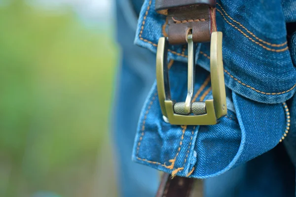 Strap on jeans, belt. A stylish vintage concept. Denim fashion. Sexy Unisex Clothing. Casual style of men accessories. The Blue Jeans style. Background of men\'s jeans with a belt. Denim pants