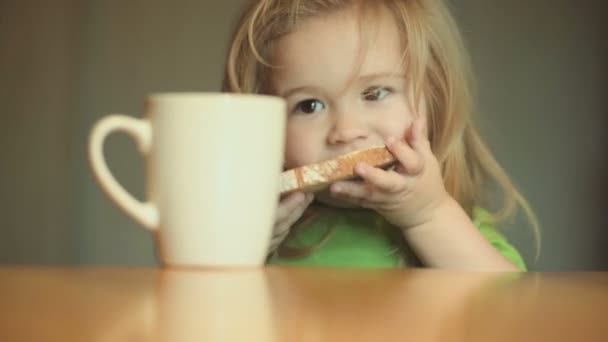 Žádné Foto koncept. Krásné dítě jí sendvič a skryje z fotoaparátu. Funny dítě v kuchyni. Snídaně s mlékem a zdravých potravin. Jídlo pro děti
