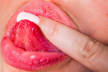 Oral seks. Güzel kadın dudaklar bir penis gibi parmak yalamak. Tatlı ve lezzetli yemekler kavramı. Aphrodisiacs. İlginçlik. Kadın ağız closeup dil. Pembe manikür ve hijyenik ruj