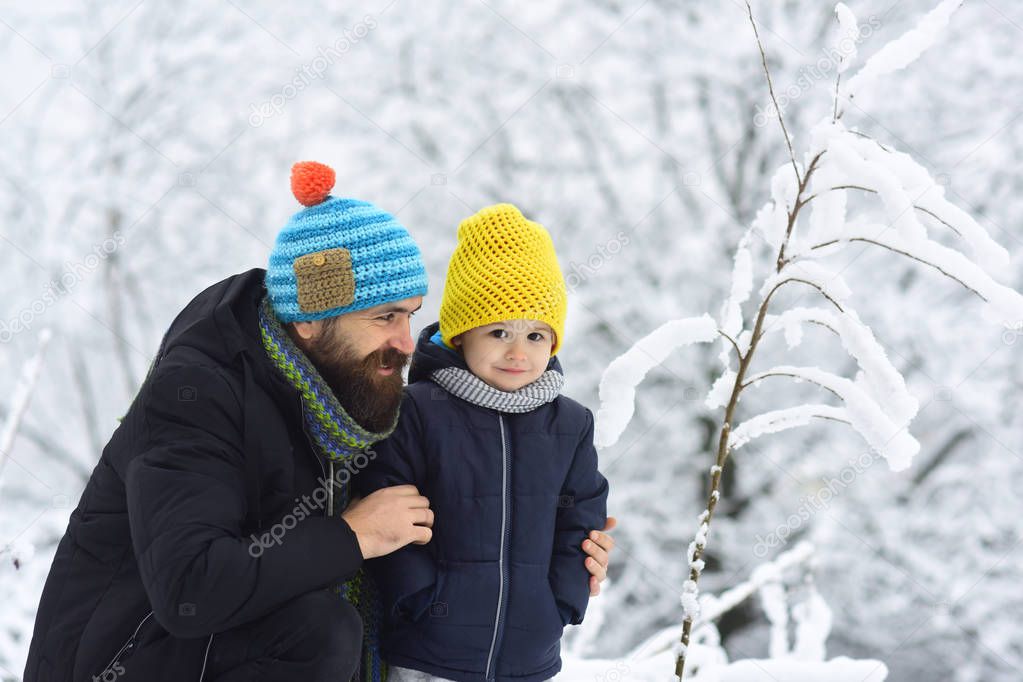 Winter family fun. Father and son playing in the park at winter time. People having fun on nature, snowy forest. Concept of friendly family, spending vacation together
