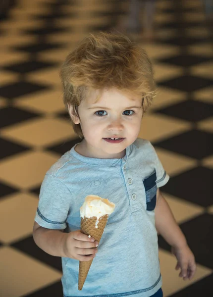 微笑む少年では 大きなコーンのアイスクリームを手に保持しています おしゃれな子供の笑顔 陽気な小さな子供が楽しく お菓子の瞬間を楽しんでいます 暖かく 幸せな家族の瞬間 ベビー食品や甘いデザート — ストック写真