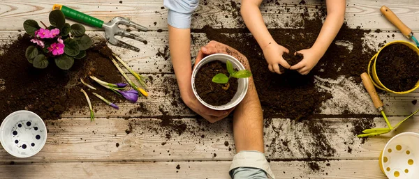 Love nature concept. The family works together. Family business. Ecology and environment. A child with parents plant flowers in pots. Together. Heart of soil. Plant flower shop. Sweet home