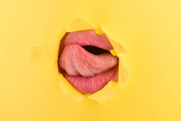 セクシーな舌と美しい若い女性 紙の穴に肖像画女唇の美しい口を閉じる ファッション写真 自然の完全な唇と舌 — ストック写真