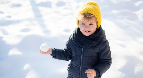 Snowballs. Child playing snowballs. Beautiful cheerful baby in the winter snow. Smile and happiness. Leisure. Winter game. — Φωτογραφία Αρχείου